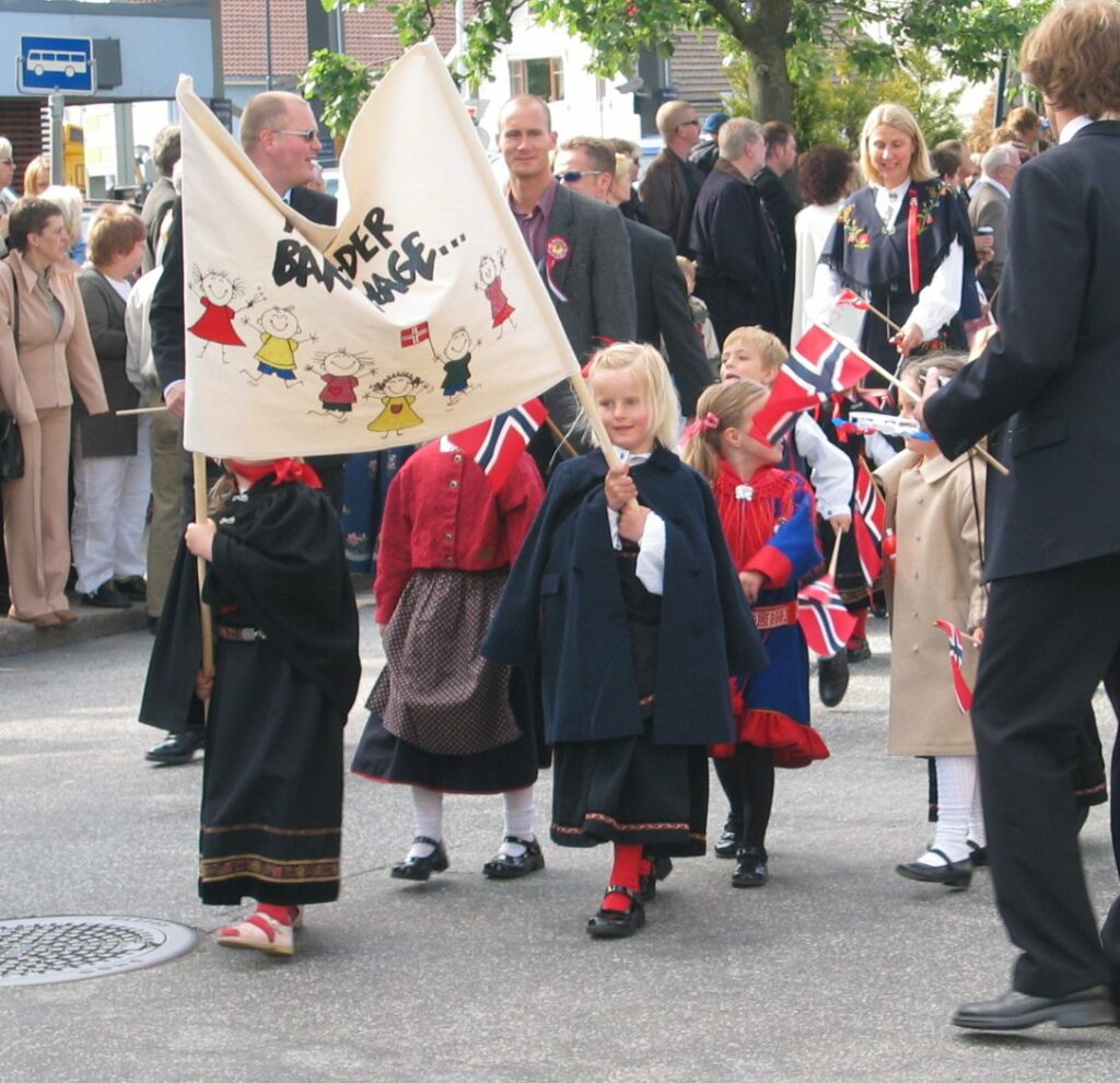 Enfants en tenue traditionnelle tenant une banderole et célébrant la fête nationale norvégienne