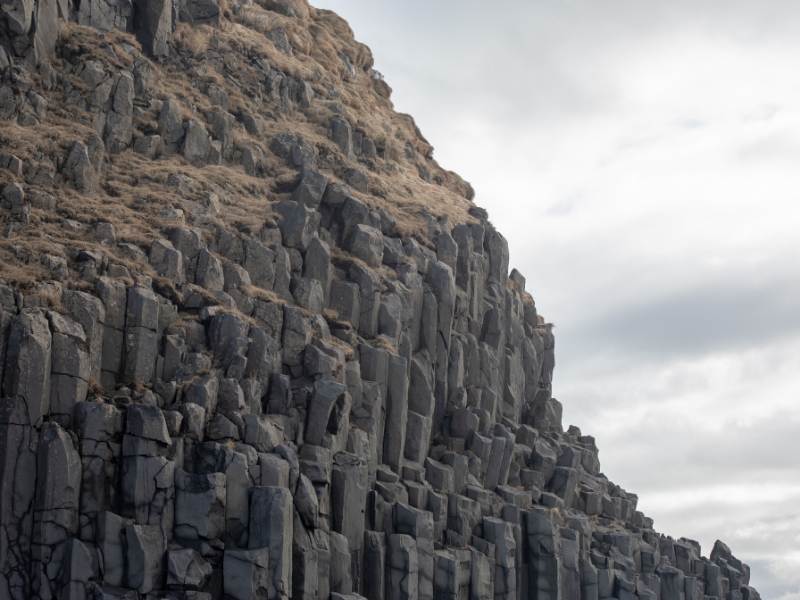 Roches de basalte de forme hexagonales sur la montagne de la plage de Reynisfjara.